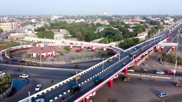The Kano metropolitan skyline rises above a busy highway interchange showcasing urban expansion modern infrastructure and the vibrant energy of the city.