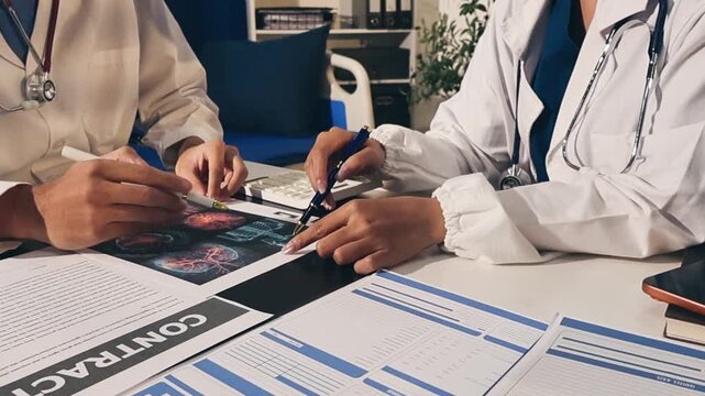 Two asian women doctors discuss meeting doctor's office medical clinic looking x-ray film consulting patient disease. Asian medical lab young women talking together discussing healthcare teamwork