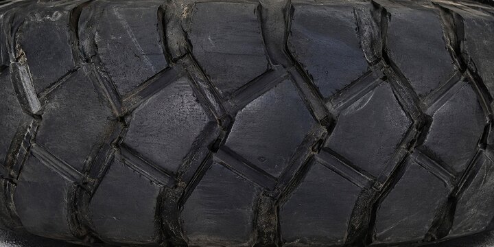 High-resolution close-up of a giant black tire texture featuring detailed rubber tread patterns, rugged industrial surface, and realistic wear. The seamless background highlights the durable structure