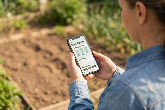 Woman viewing Lawn Planner watering schedule on smartphone