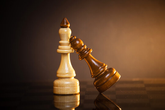 king and queen piece on a chessboard on a dark background