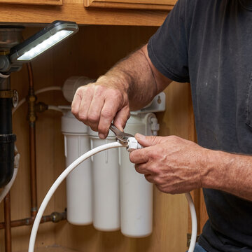 Plumber installing a multistage under-sink water filter