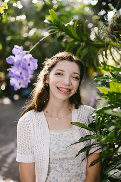 Happy teenage girl with braces in a botanical garden