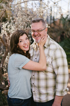 Woman affectionately holds her winking partner's face