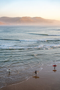 Surfers enjoying ocean waves in Imsouane Morocco at sunset