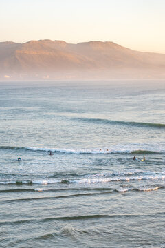 Surfers enjoying ocean waves in Imsouane Morocco at sunset