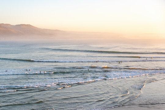 Surfers enjoying ocean waves in Imsouane Morocco at sunset