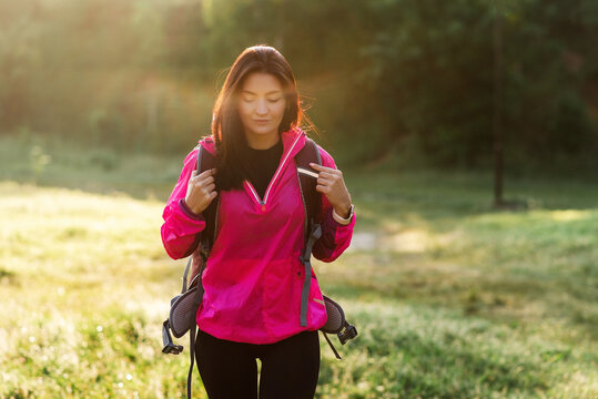 Young woman walking with backpack on meadow