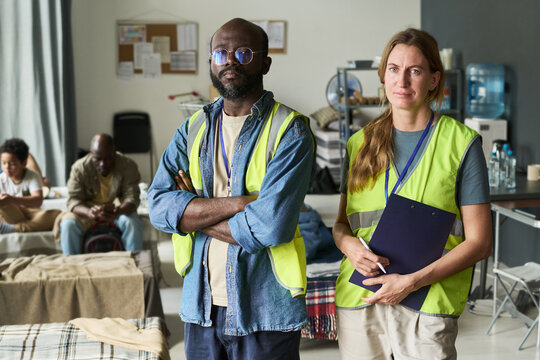 Portrait of diverse aid workers standing in temporary shelter, coordinating support for displaced families and relief operations. Ideal for humanitarian outreach, nonprofit campaigns