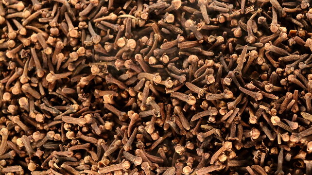 Natural dried cloves displayed in macro detail with earthy texture. Aromatic spice suitable for cooking, herbal wellness, and beverage preparation.