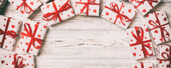 Fototapeta premium Frame of many Colorful gift boxes with red bow and heart blank copy space top view, Valentine or other holidays celebrations concept