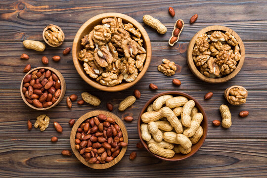 Walnut kernel halves, in a wooden bowl. Close-up, from above on colored background. Healthy eating Walnut concept. Super foods with copy space