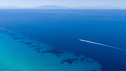 Fototapeta premium Aerial view of boat speeding over turquoise sea