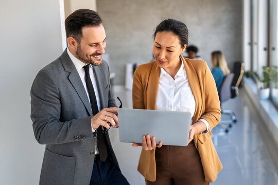 Happymultiethnic businesspeople laughing while collaborating on a new project in an office.