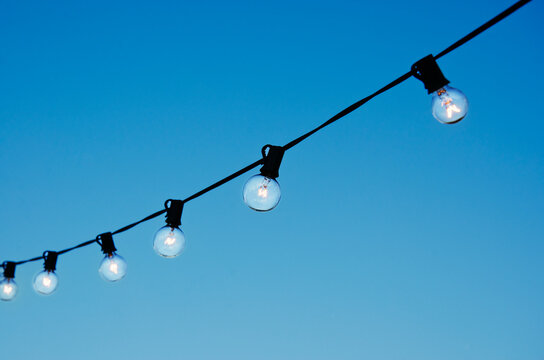 String of party lights against clear sky at twilight