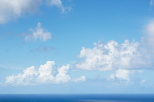 White puffy clouds above calm Caribbean Sea