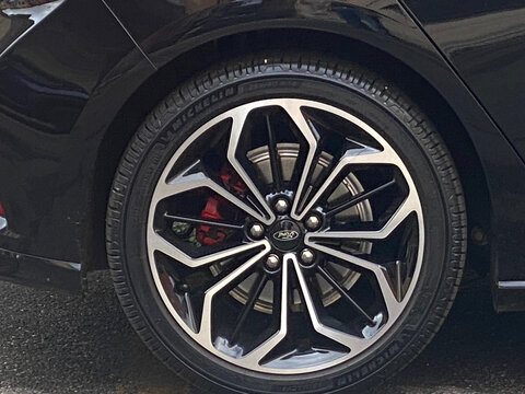 Close-up of a black Ford car wheel with red brake calipers and Michelin tires