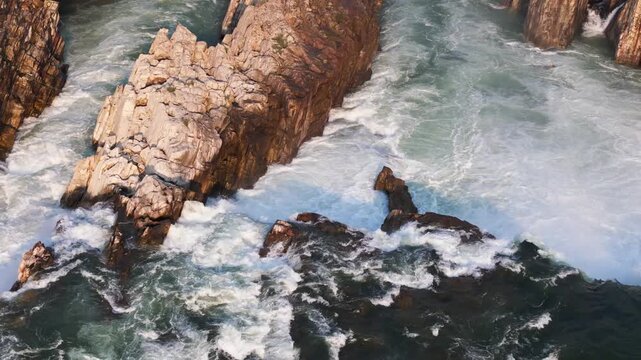 Early morning DJI Air 3 drone footage tracking left to reveal the broad cascade of Dhuandhar Waterfall on the Narmada River at Bhedaghat, Jabalpur, Madhya Pradesh, India.