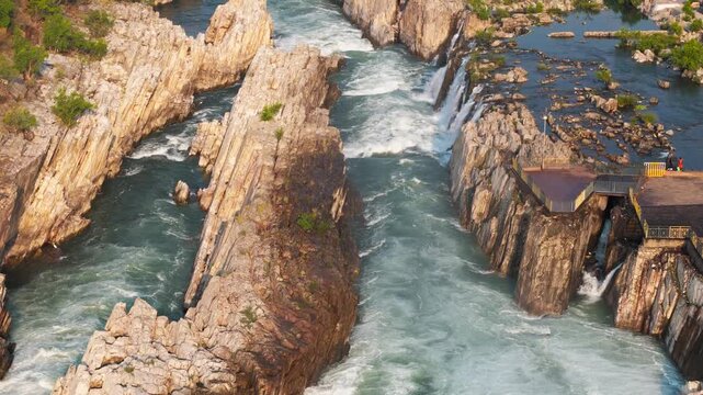 Smooth tilt-up 4K drone footage revealing Dhuandhar Waterfall and the marble gorge of the Narmada River at Bhedaghat, Jabalpur, Madhya Pradesh, India, captured in soft early morning light.