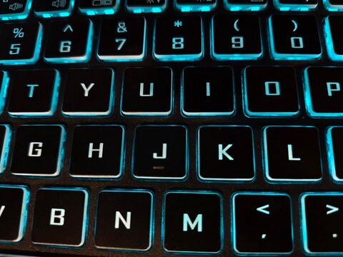 Glowing blue backlit laptop keyboard macro view with keyboard backlight lighting technology