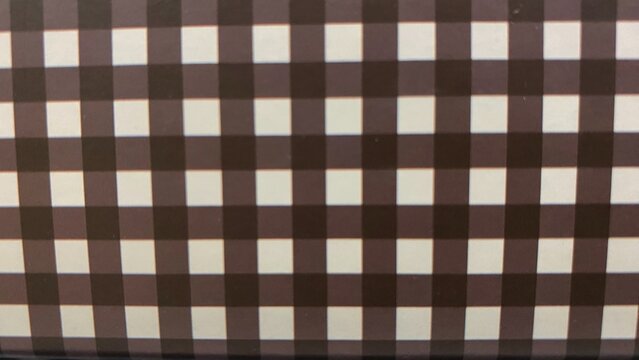 A geometric black-and-white checkerboard pattern with an optical distortion effect that creates a modern visual illusion. Suitable for use as an abstract background.