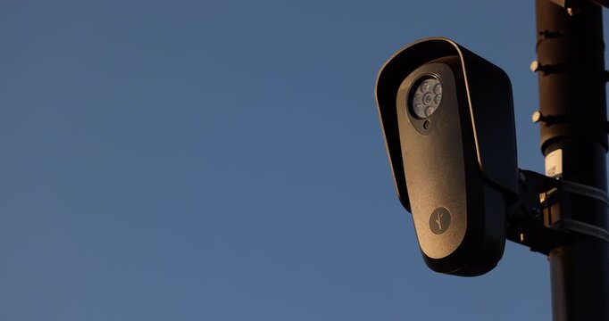 Fullerton, California, USA - July 23, 2026: An AI camera surveils a city street for car license plates.