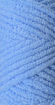 Blue fluffy yarn texture. Close-up soft chenille fabric with braided fluffy surface, smooth motion. Ideal for fashion, cozy and textile backgrounds.