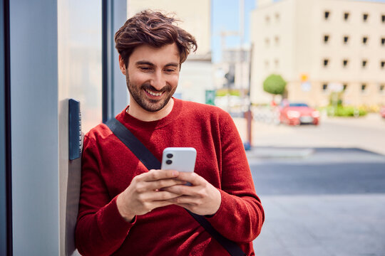 Smiling commuter using smartphone outdoors in the city