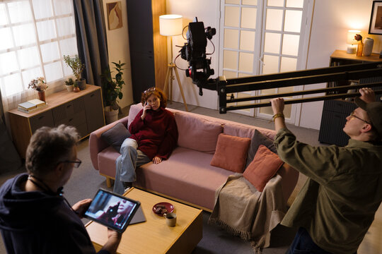 Film crew shoots a video with an actress on an indoor set