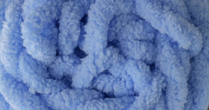 Blue fluffy yarn texture. Close-up soft chenille fabric with fluffy surface, smooth motion. Ideal for fashion, cozy and textile backgrounds.	