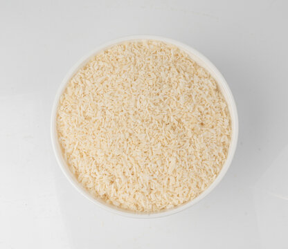 Grated coconut powder. Dry coco flakes pile, shredded desiccated coconut, tropical fruit chips