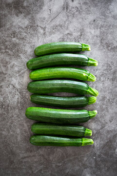 Courgettes in a row, grey background
