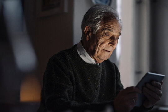 Senior man using tablet at home