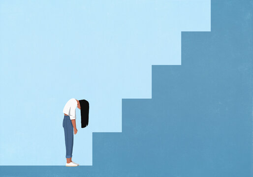 Woman with head down standing at large blue staircase