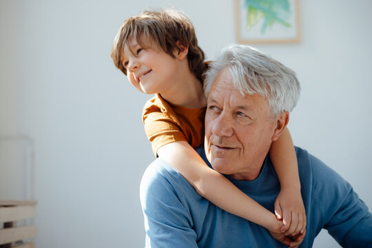 Senior man with cute grandson at home
