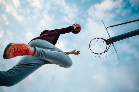 Young man playing basketball on an outdoor court