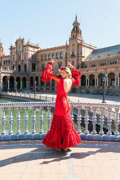 Female flamenco dancer dancing with hands raised at Plaza De Espana in Seville, Spain