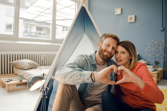 Happy couple at home camping ina tent in the livingroom