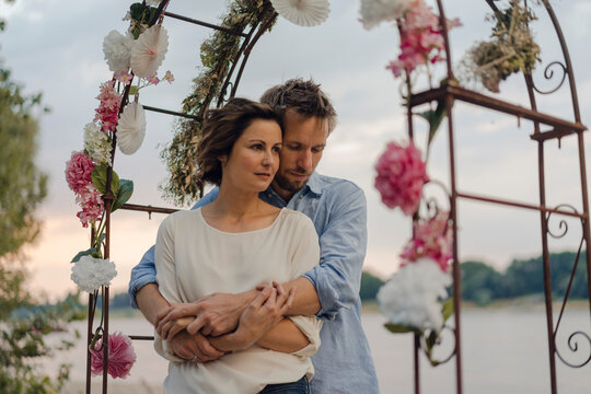 Happy couple embracing under wedding arch