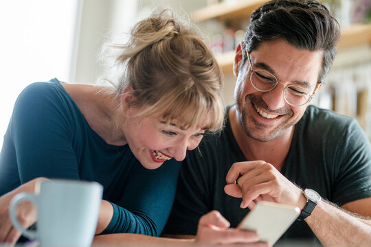 Happy couple looking at smartphone together