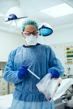 Emergeny doctor putting a swab into a plastic bag in hospital