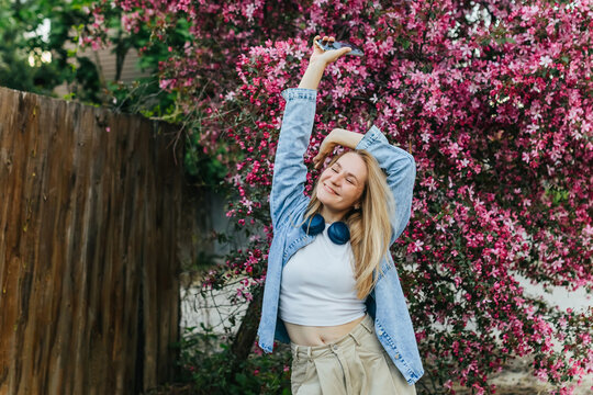 Happy woman enjoys music outdoors with smartphone