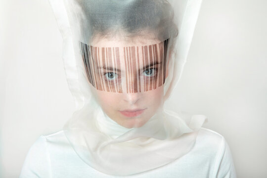 Portrait of young woman wearing transparent mask with bar code