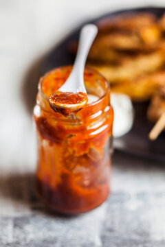 Homemade red chili sauce jar on table