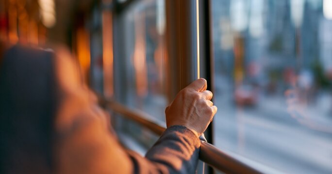 Person holding pole inside public transport