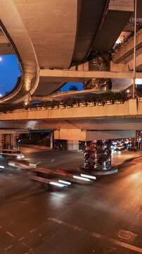 Asia, China, Shanghai, day to night cityscape vertical panning time lapse of road intersection in central Shanghai, busy with rush hour traffic and commuters