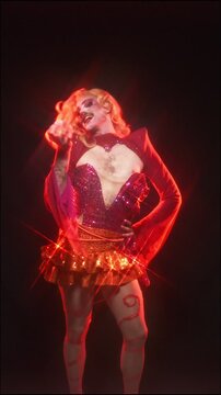 Charismatic drag queen dancing in a shiny costume