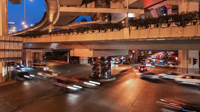 Asia, China, Shanghai, day to night cityscape zoom out time lapse of road intersection in central Shanghai, busy with rush hour traffic and commuters