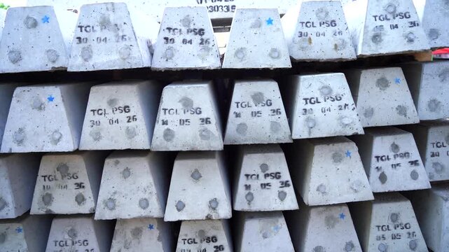 Uninstalled Railway Sleepers Stack 
Close-up view of heavy concrete railway ties and sleepers stacked outdoors at a construction site and ready for railway track installation