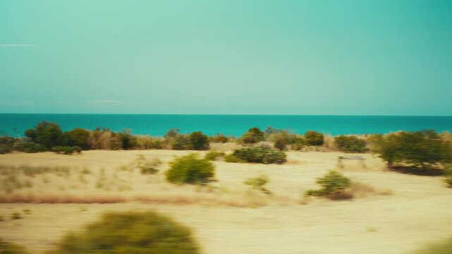 View of Italian beaches and coastlines from the window of a train during summer